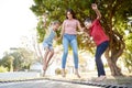 Siblings With Teenage Sister Playing On Outdoor Trampoline In Garden