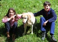 Siblings with their big labrador dog on the grass Royalty Free Stock Photo