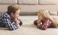 Siblings Trying To Stare Each Other Down Lying On Floor