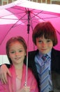 Siblings under pink umbrella Royalty Free Stock Photo