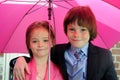 Siblings under pink umbrella Royalty Free Stock Photo