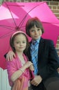 Siblings under pink umbrella Royalty Free Stock Photo