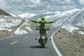 Sichuan, China - April 13, 2017:A man from Thailand standing while riding a Ducati driving to a snow mountain the local people