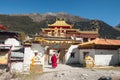 Monk Tibetan standing on gate at ancient Chunggu temple on Yading nature reserve