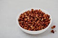 Sichuan pepper. Chinese pepper Zanthoxylum schinifolium in bowl on gray stone background Royalty Free Stock Photo