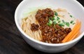 Sichuan Spicy Noodle with garlic chili oil and minced pork, serving on white bowl. Traditional food of Sichuan province. Chinese