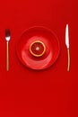 Sicilian orange cut in half on a red plate. Top view. Copy space. Creative concept