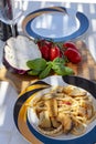 Sicilian pasta dish with traditional busiata pasta and sicilian vegetables, Viola eggplant, tomatoes served ourdoor on terrace Royalty Free Stock Photo