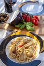 Sicilian pasta dish with traditional busiata pasta and sicilian vegetables, Viola eggplant, tomatoes served ourdoor on terrace Royalty Free Stock Photo