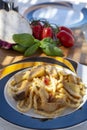 Sicilian pasta dish with traditional busiata pasta and sicilian vegetables, Viola eggplant, tomatoes served ourdoor on terrace Royalty Free Stock Photo