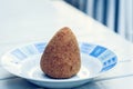 Sicilian snack, fried ball of rice arancino on a plate, tipical street food of Sicily