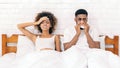 Sick african-american couple blowing noses in bed Royalty Free Stock Photo