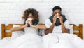 Sick african-american couple blowing noses in bed Royalty Free Stock Photo