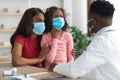 Sick daughter and mother in face masks visiting doctor Royalty Free Stock Photo