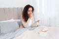 Sick African American woman with box of tissues in bed at home Royalty Free Stock Photo