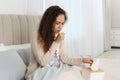 Sick African American woman with box of tissues in bed at home Royalty Free Stock Photo