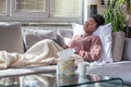 Sick African American woman with headache sitting under the blanket. Sick woman covered with a blanket lying in bed with seasonal Royalty Free Stock Photo