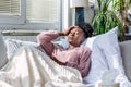 Sick African American woman with headache sitting under the blanket. Sick woman covered with a blanket lying in bed with seasonal Royalty Free Stock Photo