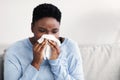 Sick black woman sneezing, holding tissue paper Royalty Free Stock Photo