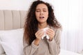 Sick African American woman with tissue in bed at home Royalty Free Stock Photo