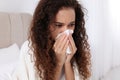 Sick African American woman with tissue in bed at home Royalty Free Stock Photo