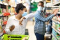 Sick African Woman Coughing In Elbow Wearing Mask In Supermarket