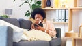 Sick afro woman streaming on phone while coughing, suffering from covid fatigue and blowing her nose with tissue. Young