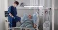 Sick aged man lying in hospital bed and signing medical document