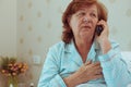 Sick aged woman calling her doctor.
