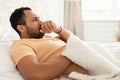 Sick Arabic Man Coughing In Fist Lying In Modern Bedroom Royalty Free Stock Photo
