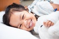 Sick asian child girl is lay down on the bed and smiling Royalty Free Stock Photo