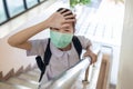 Sick asian child girl touching her forehead,checking the temperature,illness and fever,schoolgirl wear face mask has flu and cold Royalty Free Stock Photo