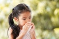 Sick asian child girl wiping and cleaning nose with tissue