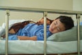 Sick Asian kid boy 2 years old lying sick in hospital bed. Royalty Free Stock Photo