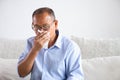 Sick asian old man using tissue paper close mouth while cough, sitting on sofa at home. Senior healthcare concept Royalty Free Stock Photo