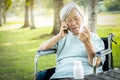 Sick asian senior woman holding bottle of medicine,.calling doctor requesting information,worried female elderly consulting,asking Royalty Free Stock Photo