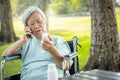 Sick asian senior woman holding bottle of medicine,.calling doctor requesting information,worried female elderly consulting,asking Royalty Free Stock Photo