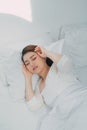 Sick Asian woman with cold sleeping on bed at home with high fever suffering from insomnia Royalty Free Stock Photo