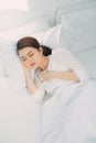 Sick Asian woman with cold sleeping on bed at home with high fever suffering from insomnia Royalty Free Stock Photo