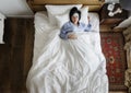 Sick Asian woman with fever sleeping on the bed Royalty Free Stock Photo