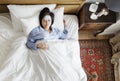 Sick Asian woman with fever sleeping on the bed Royalty Free Stock Photo