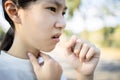 Sick asian woman has a chronic cough with tonsillitis,ill child girl touch the neck with fever,acute cough,sore throat pain Royalty Free Stock Photo