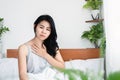 Sick Asian woman suffering from breathing problem, sore throat, and nausea in the morning  sitting in bed Royalty Free Stock Photo