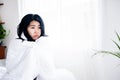 Sick Asian woman suffering from high fever covered with a blanket sitting in bed Royalty Free Stock Photo