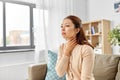 Sick asian woman touching her sore throat at home Royalty Free Stock Photo