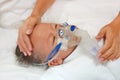 Sick baby boy and has inhalation therapy by the mask of inhaler on patient bed at hospital. Respiratory Syncytial Virus RSV Royalty Free Stock Photo