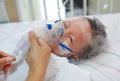 Sick baby boy and has inhalation therapy by the mask of inhaler on patient bed at hospital. Respiratory Syncytial Virus RSV Royalty Free Stock Photo