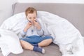 Sick baby boy with inhaler treats throat at home, the concept of health and inhalation treatment