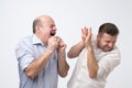 Sick bald caucasian man holding napkin or tissue, trying to cover mouth while sneezing Royalty Free Stock Photo