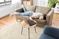 Sick bored woman with laptop lying on sofa at home Royalty Free Stock Photo